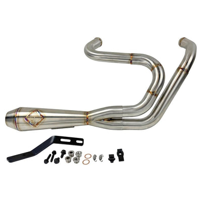 A SP Concepts stainless steel header with multiple bends rests on a gray surface, highlighting its craftsmanship. In the background, an American flag-designed welding mask nods to the customization spirit of Harley Davidson Sportster and Lanesplitter Exhaust fans.