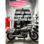 The SP Concepts Big Bore Exhaust for M8 Softail ST & Sport Glide (2018-Present) in stainless steel, featuring welded joints and a hexagonal logo emblem, rests on a metallic work surface, highlighting its premium finish.