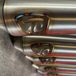 TC Bros. 2-into-1 Stainless Exhaust System for 2018-Up Harley-Davidson Softail by TC Bros., displayed with various Harley-Davidson Softail exhaust pipes in the background.