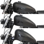 TC Bros. Frisco-Style Gas Tank Lift Kit for Harley-Davidson Sportster 1995-2003, includes two black metal brackets, a black cylindrical spacer, bolt, washer, and nut—shown on a white background.