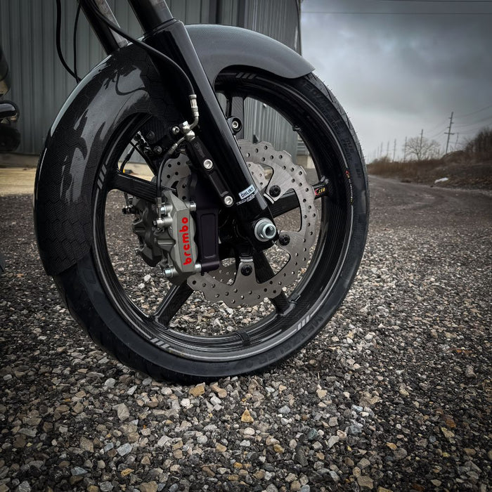 The TC Bros. Pro Series Radial Caliper Brake Line Kit for Harley Touring 2014-2023 includes silver and black bolts, washers, spacers, and two braided hoses with metal connectors, all arranged on a white background. Brand: TC Bros.