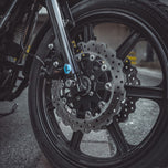 The TC Bros. 11.8" Profile Front Floating Brake Rotor for 2006-2025 Harley-Davidson features a black center with a silver, perforated, wave-patterned stainless steel surface for improved performance.
