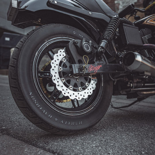 A close-up of the TC Bros. 11.5" Rear Floating Brake Rotor for 2000-2023 Harley-Davidson, featuring a black center hub and silver perforated outer ring in the distinctive TC Bros. profile.