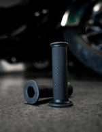 A pair of Speedwell Bear Grips for 7/8" and 1" handlebars, in textured black, are displayed upright before a Speedwell product box on a dark surface.