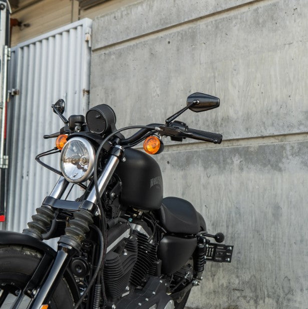 An Arlen Ness Mini Stocker Forged Mirror, Black - Left motorcycle parked in front of a building.