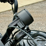 Two black metal mounting brackets for the TC Bros. Gauge Relocation Bracket for 2022-Up Harley-Davidson Nightster, shown with screws, washers, and nuts on a white background.