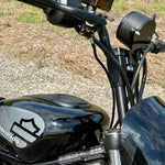 Two black metal mounting brackets for the TC Bros. Gauge Relocation Bracket for 2022-Up Harley-Davidson Nightster, shown with screws, washers, and nuts on a white background.