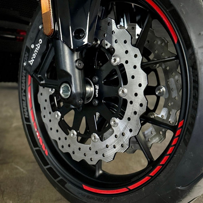 The TC Bros. Profile™ Front Floating Brake Rotor, compatible with 2023+ Harley Touring Bagger and 2021+ Pan America models, features a perforated round design crafted from high-carbon stainless steel with a black center and silver edge.