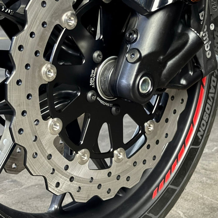 The TC Bros. Profile™ Front Floating Brake Rotor, compatible with 2023+ Harley Touring Bagger and 2021+ Pan America models, features a perforated round design crafted from high-carbon stainless steel with a black center and silver edge.