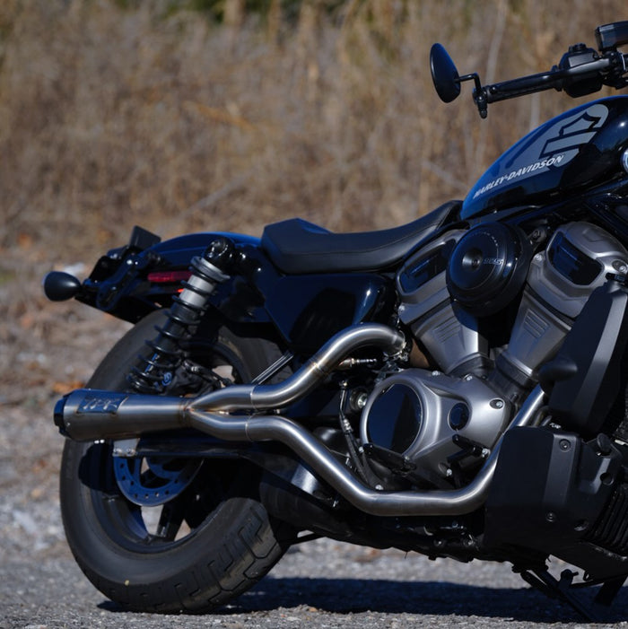 A motorcycle parked on a gravel road, highlighted by the high quality materials and TIG welded craftsmanship of its Two Brothers Comp S Stainless 2 into 1 Exhaust for Harley Nightster RH975 2022-UP.