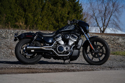 A Harley Nightster RH975 2022-UP parked on a gravel road with high quality materials and TIG welded, outfitted with the Two Bros. Comp S Stainless 2 into 1 Exhaust from Two Brothers.