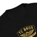 Toddler wearing a TC Bros. Winged Wheel Black/Gold cotton t-shirt, paired with jeans.