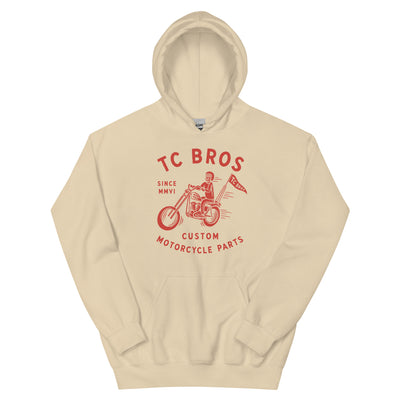 Beige Rider Hoodie - Sand featuring a red graphic of a motorcycle and text advertising TC Bros. custom motorcycle parts, printed on demand.