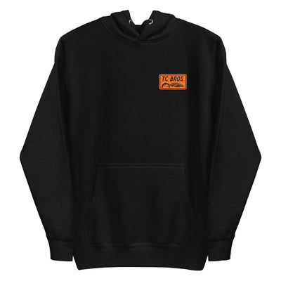 Badge Hoodie - Black/Orange, a classic streetwear piece, with a TC Bros logo embroidered on the left chest.