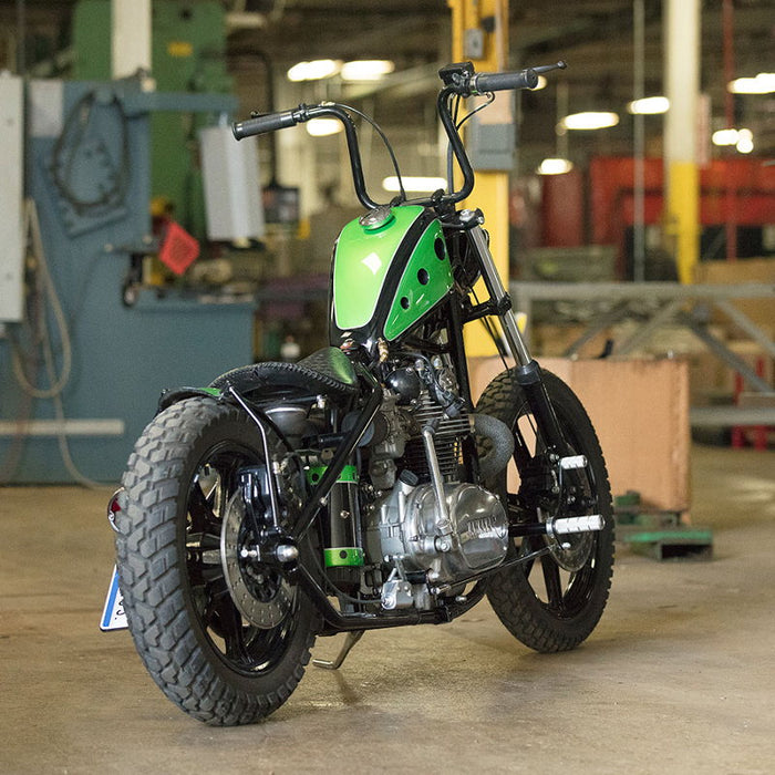 A TC Bros. motorcycle parked in a warehouse.