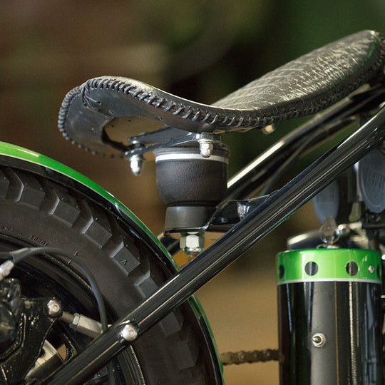 A close up of the TC Bros. Air Ride Solo Seat Bracket Kit, showcasing its adjustability and vibration dampening features.