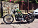 A black TC Bros. motorcycle with TC Bros. 1" Bootlegger Handlebars - Black parked on the side of the road.