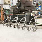 TC Bros. Weld-On Hardtail Kit for 1982-2003 Harley-Davidson Sportster with stock width tire, by TC Bros., includes a steel frame with seat tube and chain stays plus hardware components, all neatly arranged on a white background.