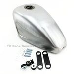 The Mid-USA 2.3 Gal. Sportster-Style Tank With Scalloped Sides, unpainted and ideal for custom builds, includes mounting hardware—bolts, washers, rubber grommets, and two black metal brackets—and is shown on a white background.