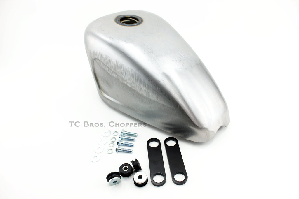 The Mid-USA 2.3 Gal. Sportster-Style Tank With Scalloped Sides, unpainted and ideal for custom builds, includes mounting hardware—bolts, washers, rubber grommets, and two black metal brackets—and is shown on a white background.