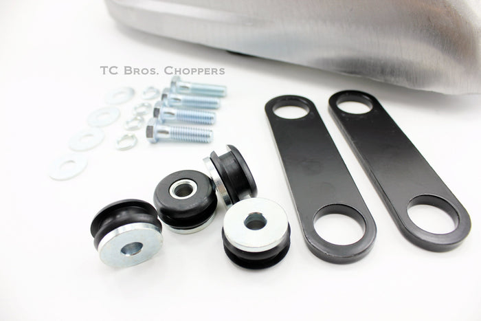 The Mid-USA 2.3 Gal. Sportster-Style Tank With Scalloped Sides, unpainted and ideal for custom builds, includes mounting hardware—bolts, washers, rubber grommets, and two black metal brackets—and is shown on a white background.