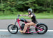 A man riding a Moto Iron® 2.1 Gal. Narrow Alien Chopper Gas Tank on a road.