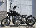Moto Iron® 3.1 Gallon King Sportster Gas Tank for 1995-2003 Harley-Davidson Sportster shown unpainted, with included mounting hardware—bolts, washers, and rubber fittings—arranged in front of the tank.