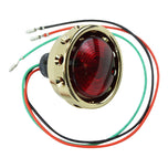 A red Mid-USA tail light with Brass Vintage Drilled Tail Light.