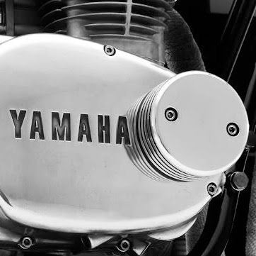 A black and white photo of a Yamaha motorcycle engine featuring Hugh&