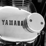 A Hughs HandBuilt Yamaha XS650 Bolt-On Oil Cooler piston cap with a gasket from Hughs Handbuilt.