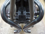A close up of a motorcycle engine with Yamaha XS650 "Double D" Exhaust System by Pandemonium custom pipes and Pandemonium exhaust pipes.