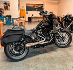 The SP Concepts Big Bore Exhaust M8 Softail 2018-Present - Stainless features polished stainless steel with visible welds and an engraved logo, designed for Monoshock Softail models, and is displayed on a gray work surface.