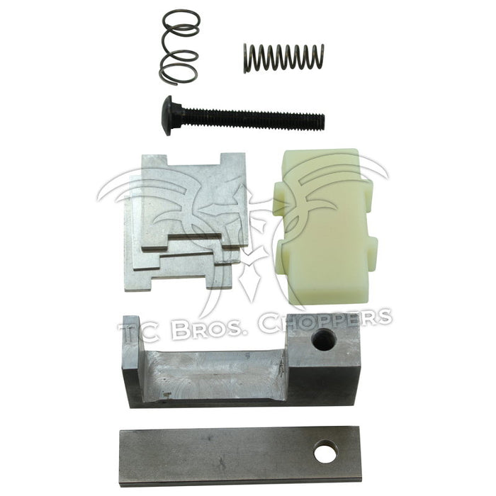 Various metal and plastic motorcycle parts, including the Hayden Enterprises M6 Self-Adjusting Primary Chain Tensioner for 1991-2003 Harley-Davidson Sportster, plus springs, bolt, brackets, and spacers arranged on a white background.