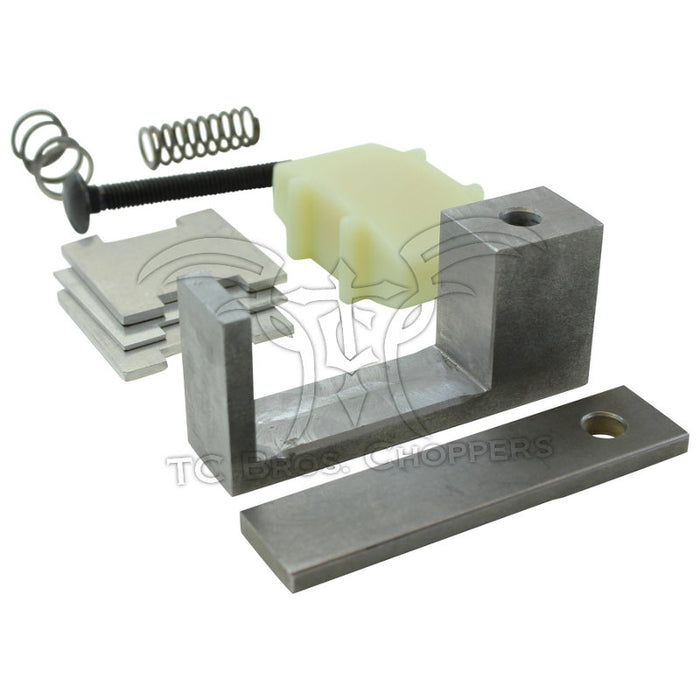 Various metal and plastic motorcycle parts, including the Hayden Enterprises M6 Self-Adjusting Primary Chain Tensioner for 1991-2003 Harley-Davidson Sportster, plus springs, bolt, brackets, and spacers arranged on a white background.