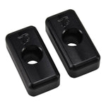 Two black rectangular metal blocks, TC Bros. Heavy Duty Billet Axle Adjusters for 1991-2005 Harley-Davidson Dyna, each with a central hole, are displayed on a white background. One block has the TC Bros. logo engraved on its surface.