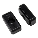 Two black rectangular metal blocks, TC Bros. Heavy Duty Billet Axle Adjusters for 1991-2005 Harley-Davidson Dyna, each with a central hole, are displayed on a white background. One block has the TC Bros. logo engraved on its surface.
