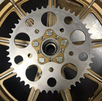 A close up of a HHB Harley Davidson Sprocket Lock System - Gold sprocket wheel by Hughs Handbuilt.