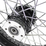 A close up of a black Moto Iron® Black Rear 40 Spoke Wheel 16"x3" (fits Harley FLT 00-01, FXST 00-07, Dyna 00-05, Sportster 00-04) with a billet hub on a white background.