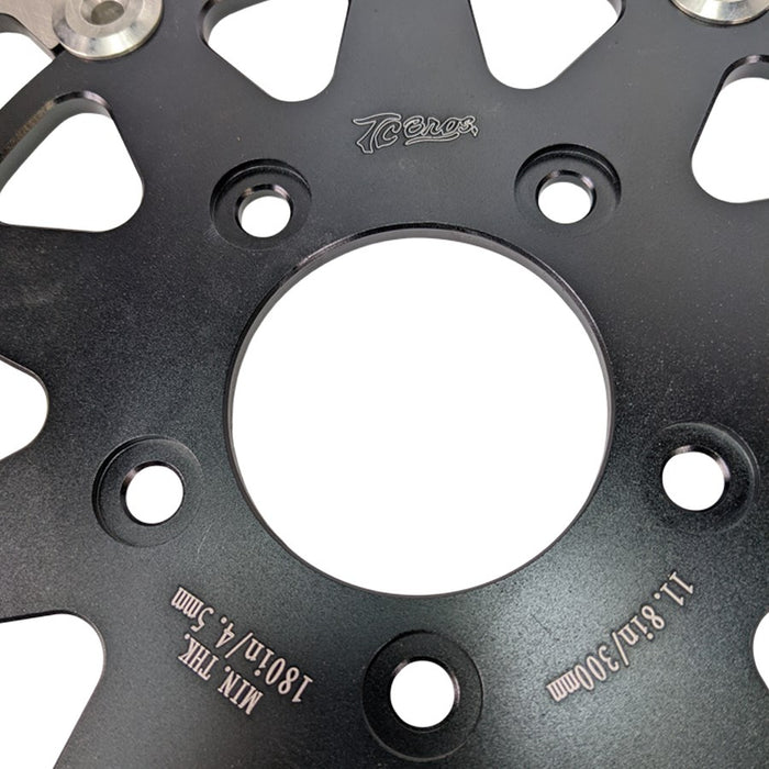 The TC Bros. 11.8in Front Floating Brake Rotor for 2006-up Harley Models features a metal disc with a black center hub and drilled holes for optimal performance and durability on your ride.