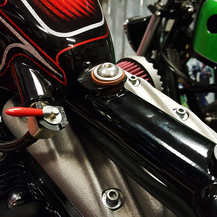 A close up of a Moto Iron® 1/4" Fuel Valve Petcock 90 Degree compact motorcycle engine.