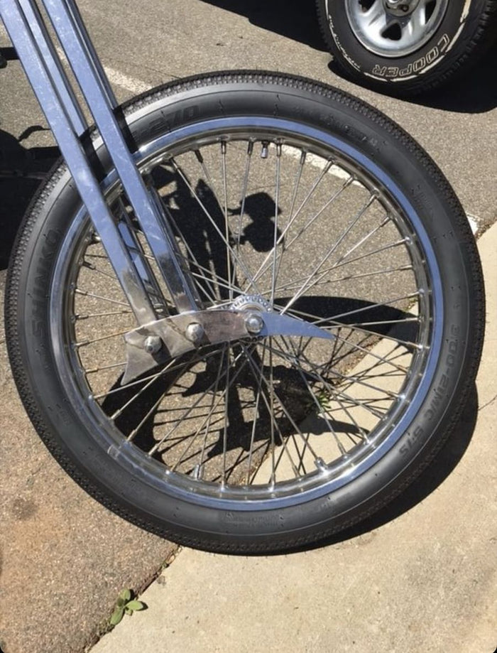 A Shinko motorcycle tire is parked on the side of the road.