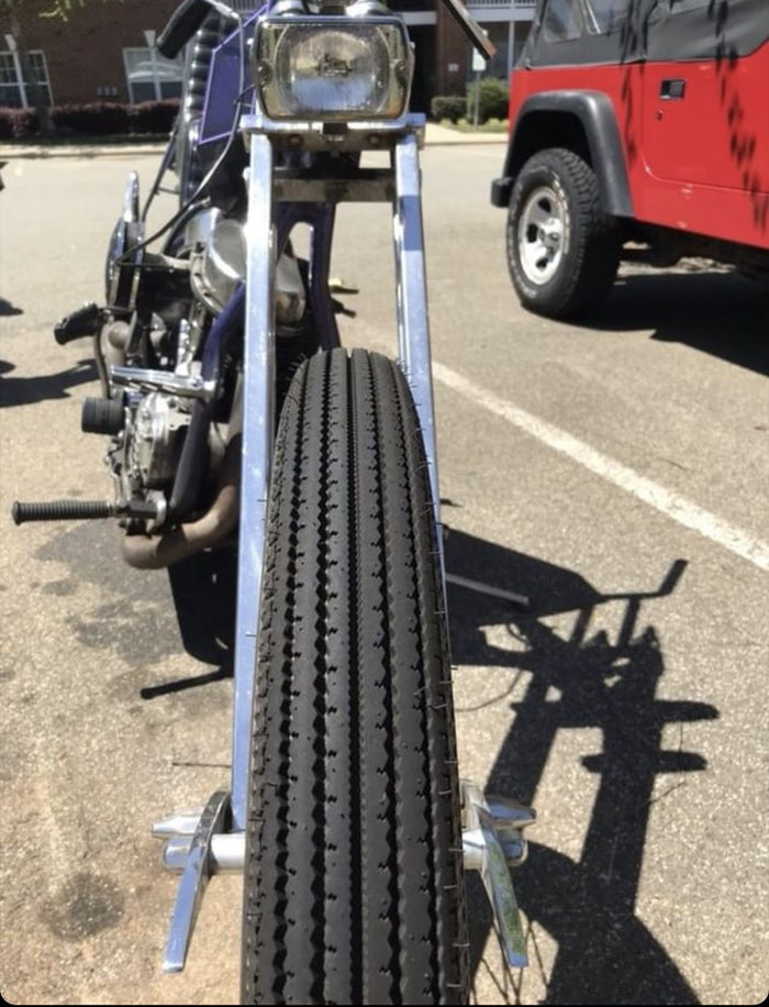 A Classic motorcycle with a Shinko 270 Vintage Style Front Tire 3.00-21 57S on it parked in a parking lot.