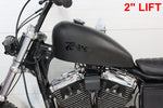 TC Bros. Frisco-Style Gas Tank Lift Kit for Harley-Davidson Sportster 1995-2003, includes two black metal brackets, a black cylindrical spacer, bolt, washer, and nut—shown on a white background.