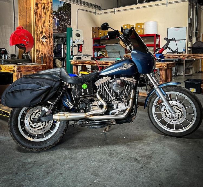 A blue SP Concepts motorcycle parked in a garage.