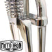 Two Moto Iron® Springer Front Ends for Harley-Davidson frames with 1" necks—one chrome, one black—are displayed side by side with a metal rod and two small parts. Ideal for custom Harley-Davidson springer setups.