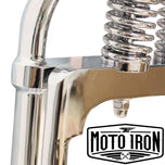 Two Moto Iron® Springer Front Ends for Harley-Davidson frames with 1" necks—one chrome, one black—are displayed side by side with a metal rod and two small parts. Ideal for custom Harley-Davidson springer setups.