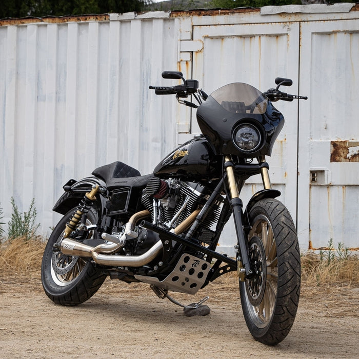 A stylish Arlen Ness Mini Oval Mirror -Black Left motorcycle parked in front of a small building.