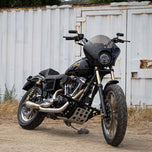 The TC Bros. Front Crash Bar for 1991-2017 Harley-Davidson Dyna is a black metal engine guard bracket with side mounts, bolts, washers, and extra metal pieces—perfect as a front crash bar for your Dyna motorcycle.