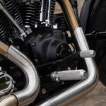 A TC Bros. Mid Controls Kit for 1991-2017 Harley-Davidson Dyna (no footpegs), featuring black metal brackets, assorted bolts, washers, nuts, bushings, and a metal rod arranged on a white background.