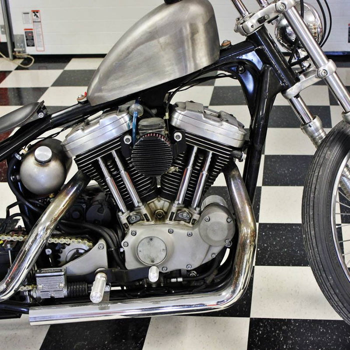 A TC Bros. Finned Black Air Cleaner S&S Super E & G Carbs vintage style motorcycle parked in a garage.